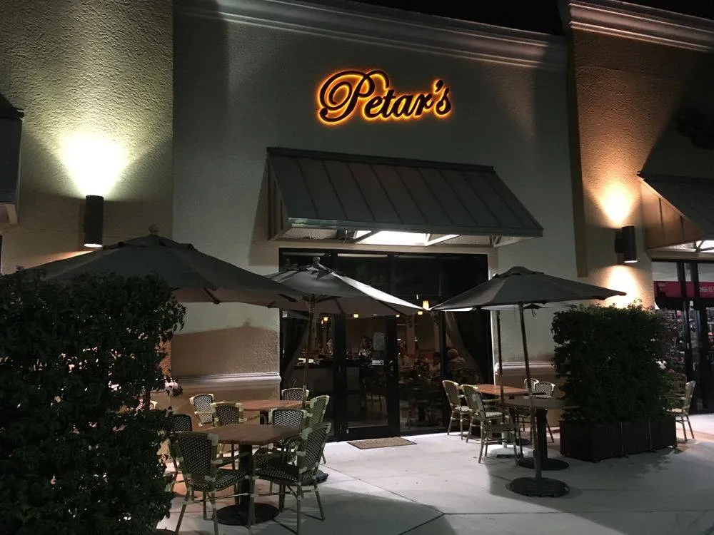 Petar's Restaurant at night, with patio tables out front